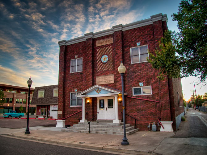 Historic red brick building on a small-town street corner at dusk
